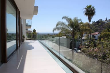 FS 1500 rahmenloses Glasgeländer auf Hangvilla-Balkon mit Palmen und Stadtpanorama