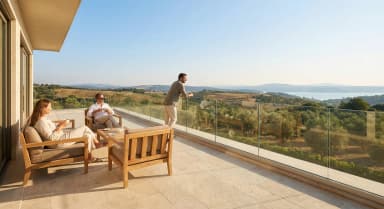 FS 1500 rahmenlose Glasbrüstung an modernem Wohngebäude mit geschwungenem Balkon und Gartenlandschaft