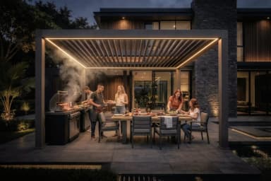 Paar genießt Kaffee unter einer Luxa 700 Pergola mit Glaswänden, LED-Beleuchtung und Zip-Screens an einem Regentag
